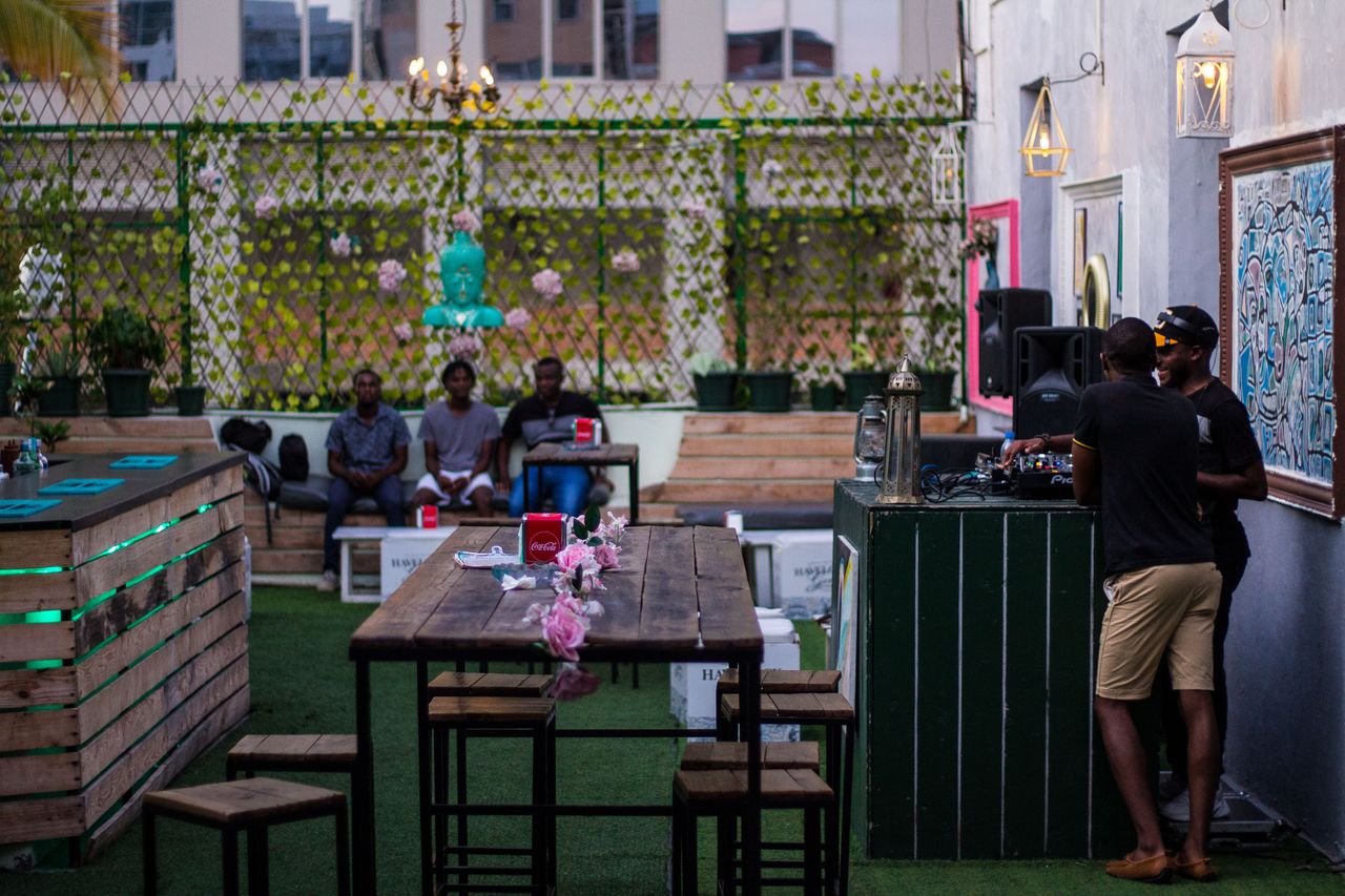 A vibrant outdoor bar in Luanda with people relaxing and enjoying the ambiance.